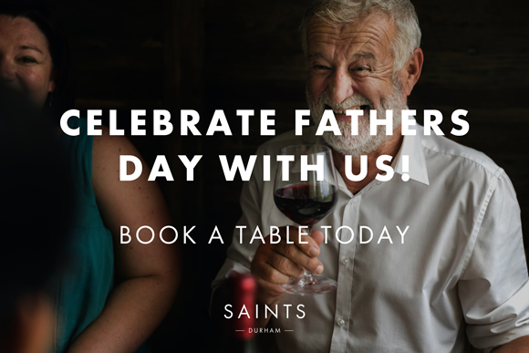 Saints Bar Fathers Day concept, man holding red wine glass smiling, talking to family members